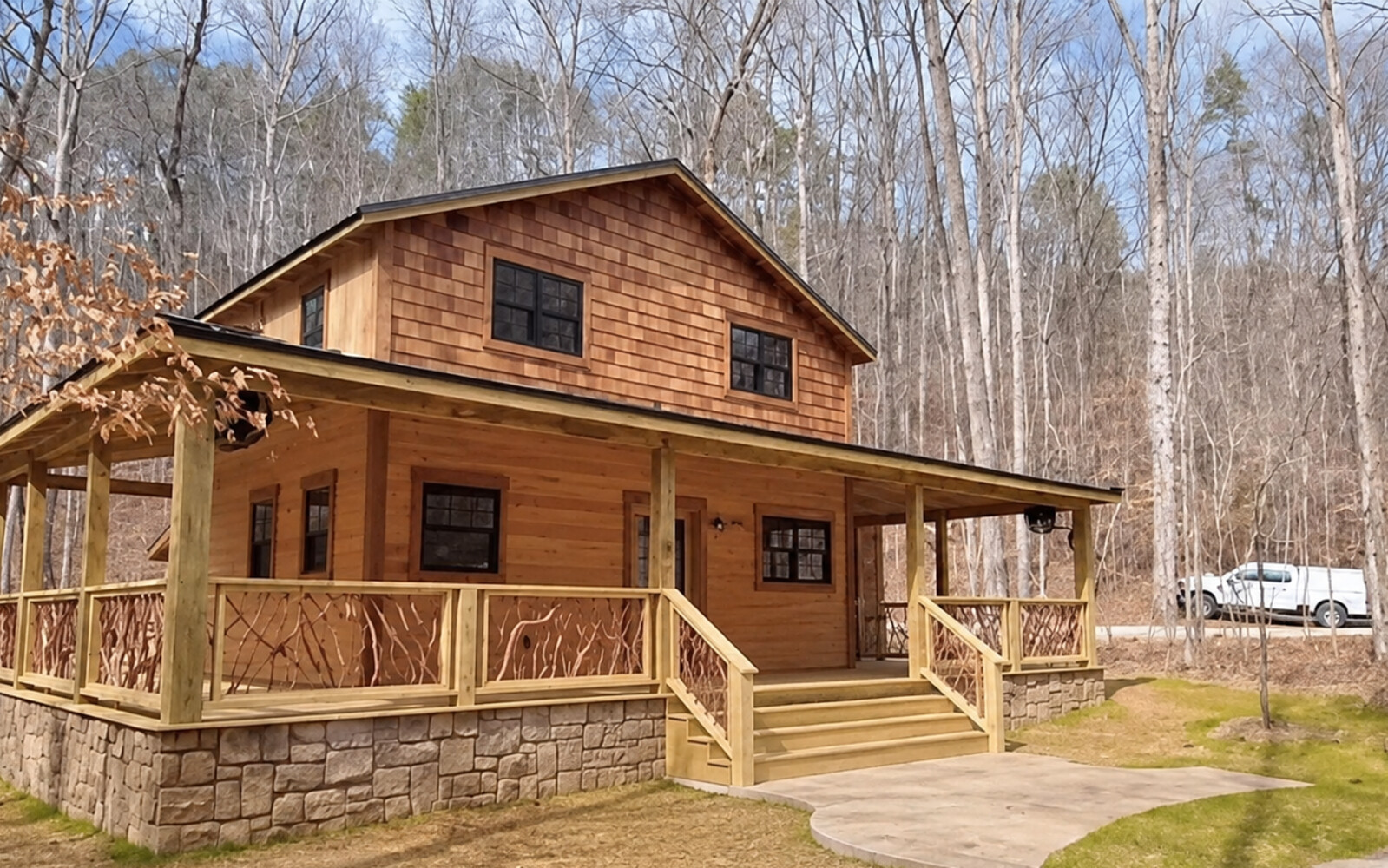 Completed DSLD custom wood home with a wraparound porch and stone foundation