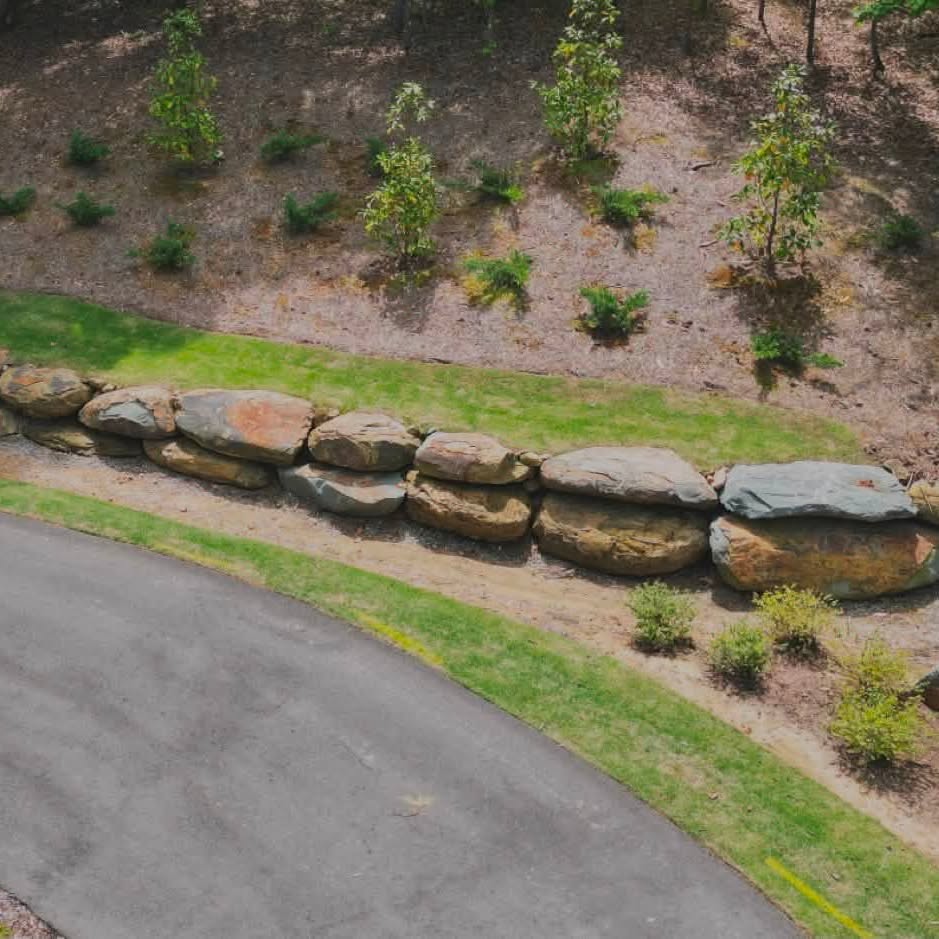 Large natural boulder retaining system along a residential drive