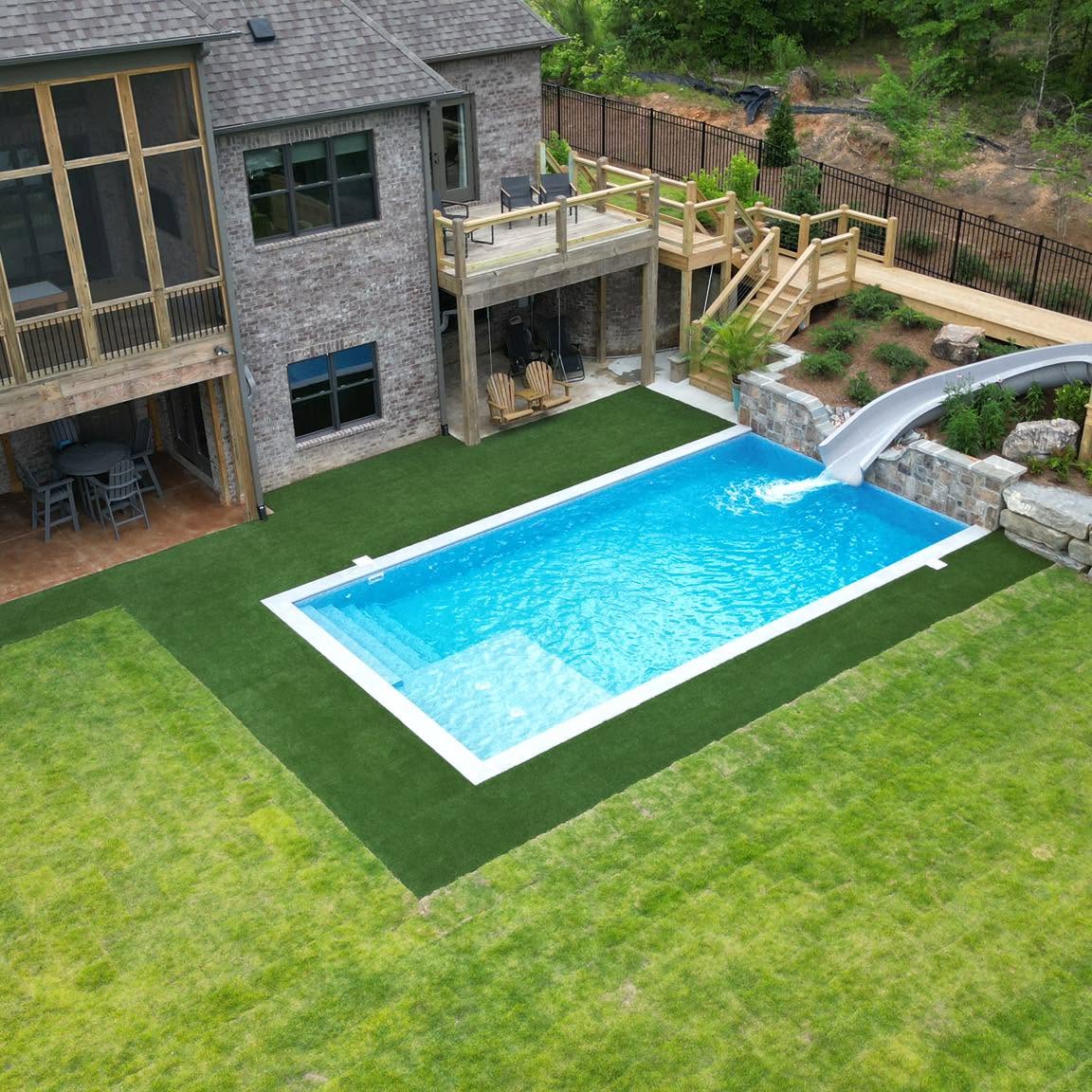 Aerial view of a DSLD pool with integrated slide, deck and landscape